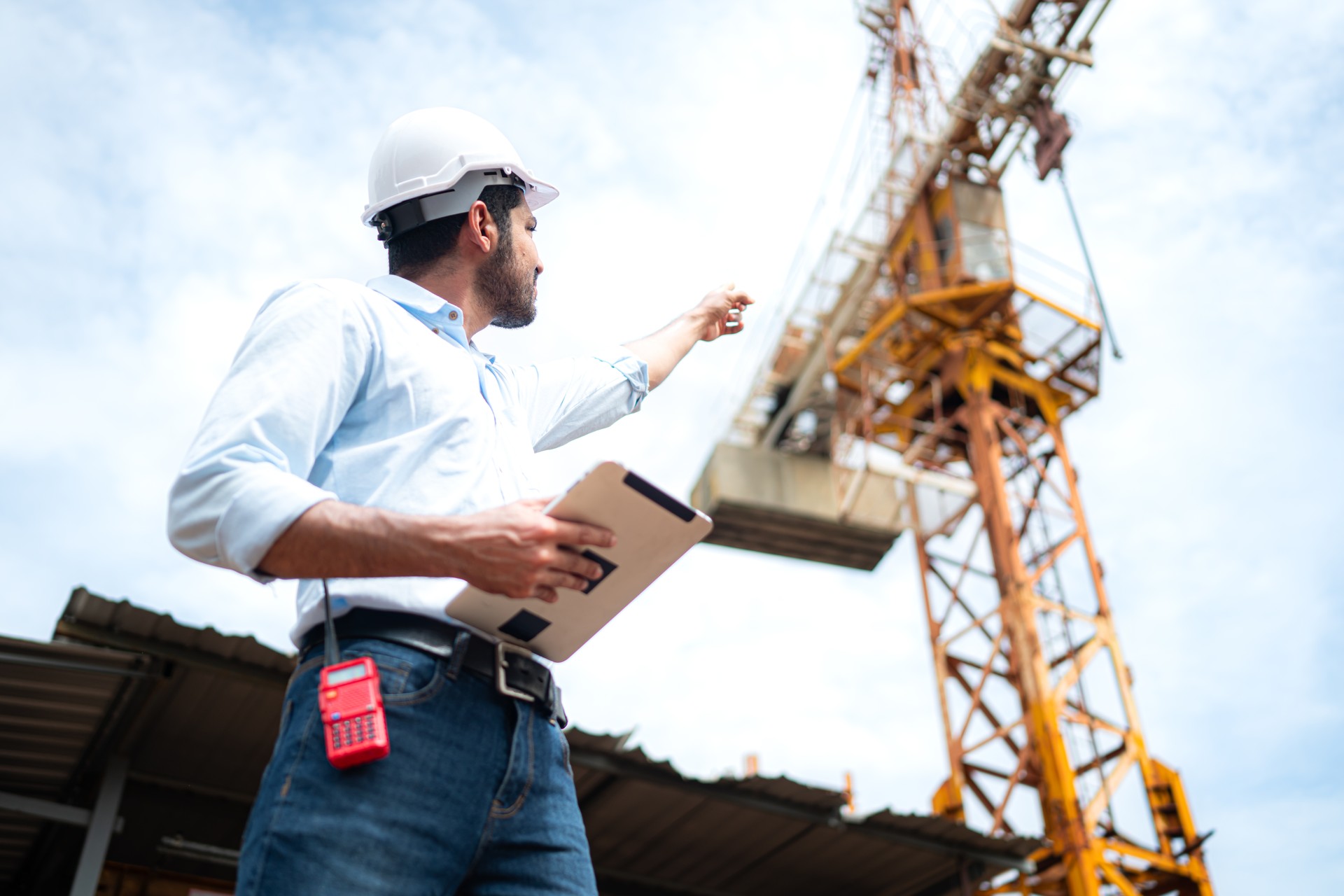 Portrait of engineer with tower crane for lift and move objects on building construction sites